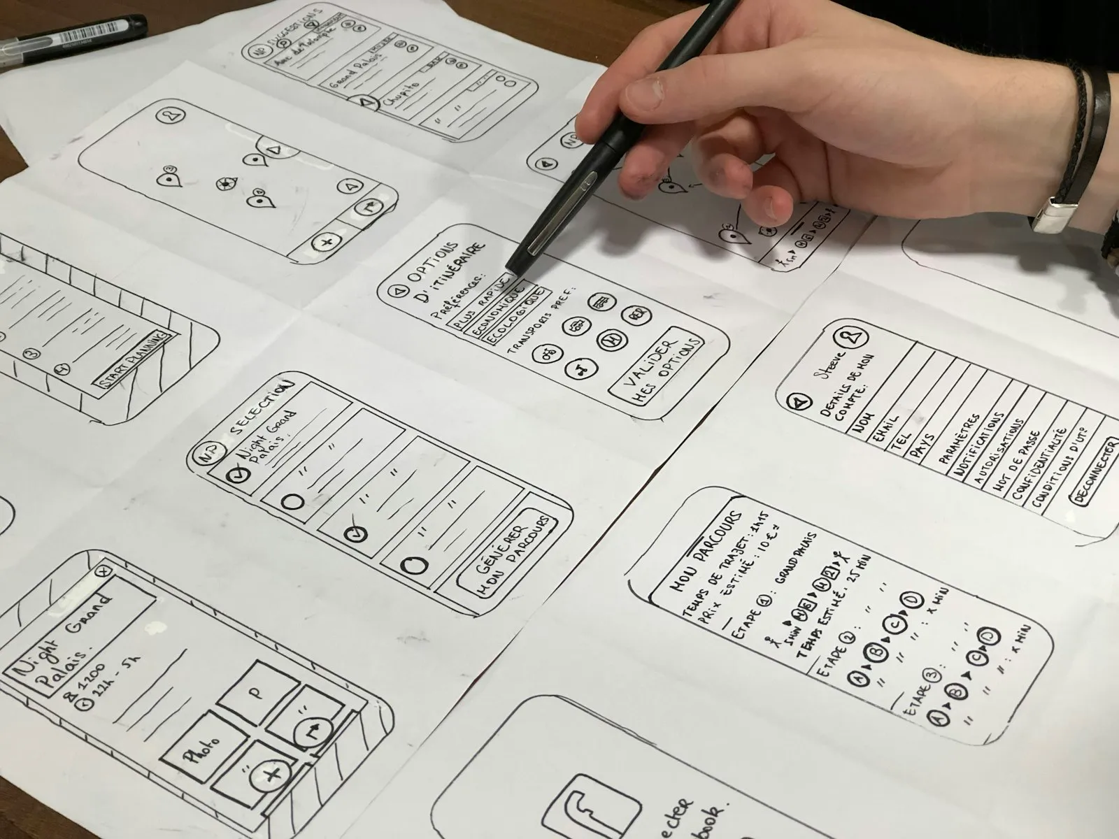 A person sketching app screen layouts on paper