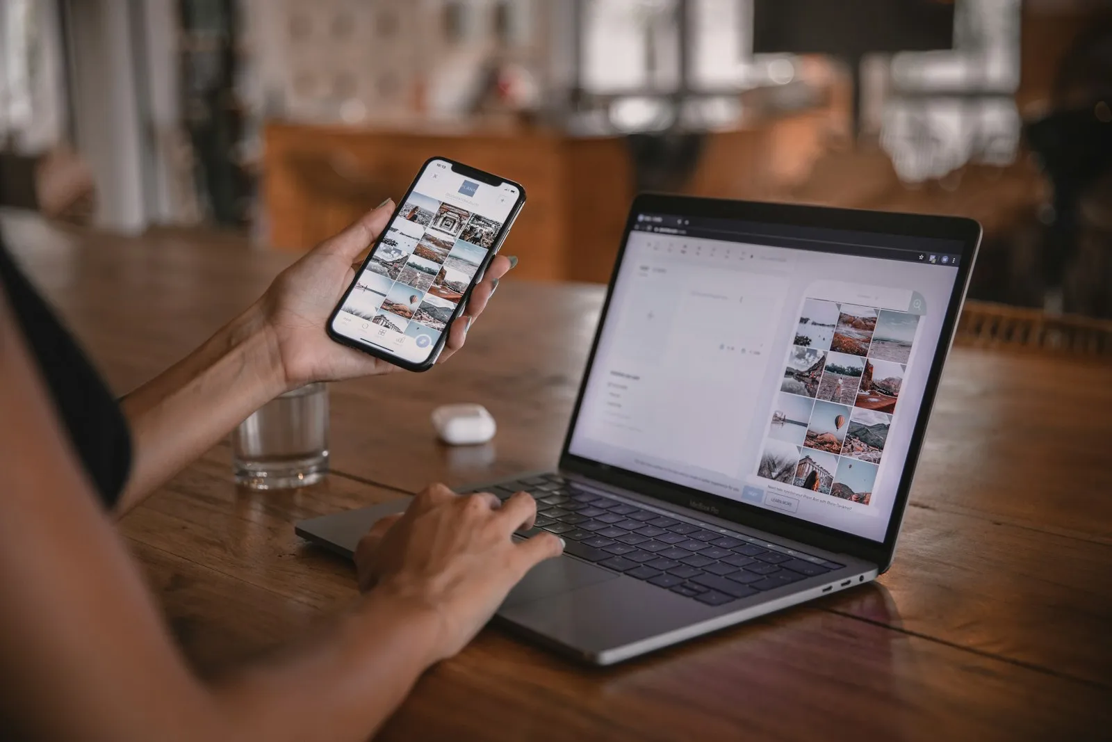 A person using a shopping app on a phone in front of a laptop