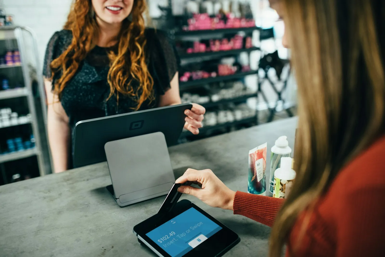 A customer paying on a tablet point-of-sale system in a shop